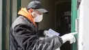 Pengemudi kereta kuda mendatangi sebuah rumah di distrik ke-3 di Wina, Austria pada 8 April 2020. Kereta yang disebut Fiaker yang biasanya mengangkut turis berkeliling, kini semenjak pandemi Corona beralih fungsi menjadi pengantar makanan untuk warga lanjut usia di daerah tersebut. (ALEX HALADA/AFP)