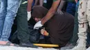 Seorang wanita menangis disamping tubuh anaknya tewas dalam insiden tenggelamnya perahu yang mengangkut ratusan imigran di Al-Beheira, Mesir, (22/9). Setidaknya 52 penumpang ditemukan tewas dan ratusan lainnya masih hilang. (REUTERS/Mohamed Abd El Ghany)