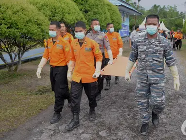 Tim SAR gabungan membawa tandu untuk memindahkan jenazah penumpang Pesawat AirAsia QZ8501 dari KRI Banda Aceh menggunakan helikopter Basarnas tiba di Lanud Iskandar Pangkalan Bun, Kalteng, Rabu (7/1/2015). (Liputan6.com/Andrian M Tunay)