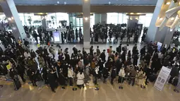 Penumpang yang mengenakan masker antre untuk menaiki pesawat pada malam liburan Tahun Baru Imlek di terminal penerbangan domestik bandara Gimpo di Seoul, Korea Selatan, Kamis (11/2/2021). Liburan Tahun Baru Imlek adalah salah satu hari libur tradisional utama negara itu. (AP Photo/Ahn Young-joon)