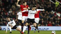 Bek Manchester United, Daley Blind (tengah) berebut bola dengan pemain Derby County, Tom Lawrence pada laga PIala FA di Old Trafford, Manchester, (5/1/2018). Manchester United menang 2-0. (Martin Rickett/PA via AP)