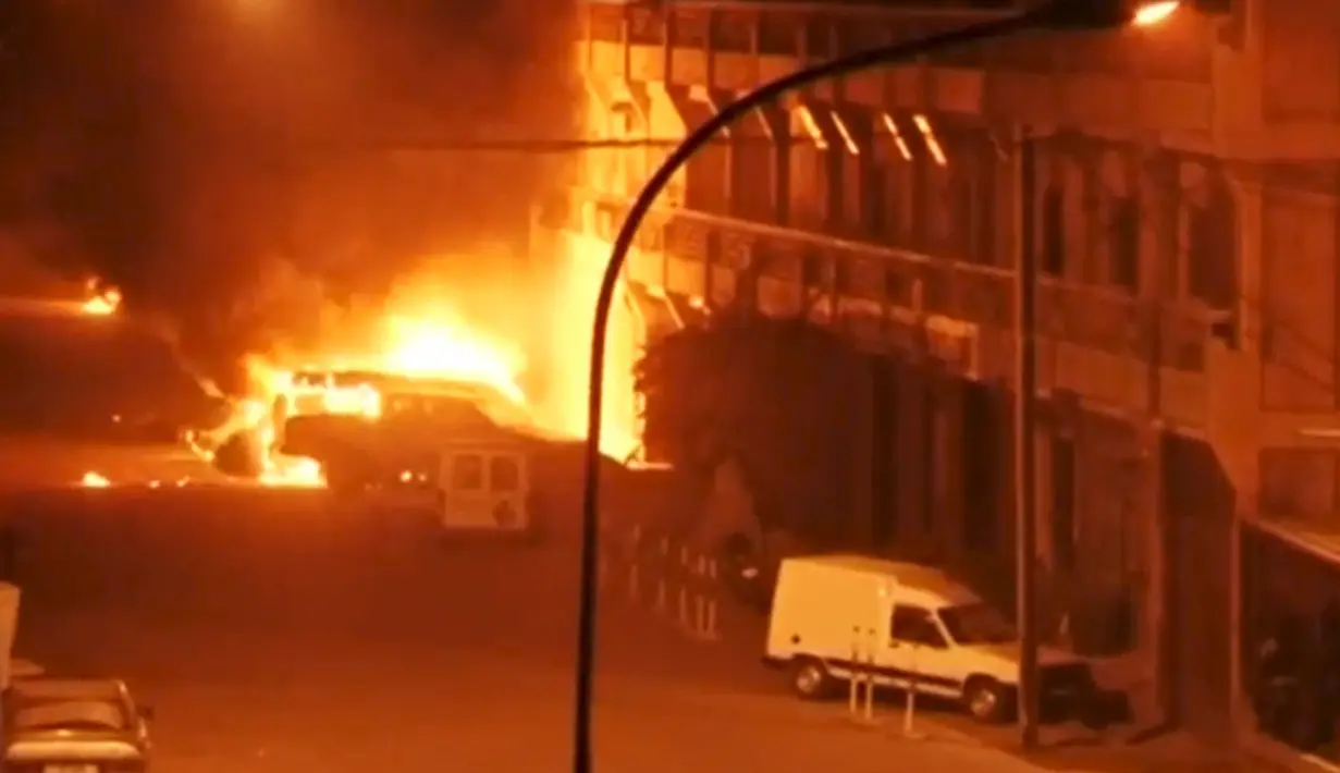 Tampak kendaraan terbakar didepan hotel Splendid, Ouagadougou, Burkina Faso, Jumat (15/1). Peristiwa terjadi setelah adu tembak antara pihak keamanan dan pasukan bersenjata yang diduga kelompok agama radikal. (REUTERS / Reuters TV)