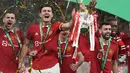 <p>Pemain Manchester United atau MU Bruno Fernandes (kanan tengah) dan Harry Maguire merayakan trofi juara Carabao Cup 2022/2023 usai kalahkan Newcastle United pada partai final di Stadion Wembley, Senin dini hari WIB (27/2/2023). Keberhasilan ini menuntaskan puasa trofi terpanjang Setan Merah. (AP Photo/Alastair Grant)</p>