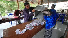 Petugas KPPS mengeluarkan surat suara yang akan dihitung di TPS 17 Wukirsari,Cangkringan,Sleman, (9/12). KPUD Kabupaten Sleman menyelengarakan Pemilukada dengan kandidat dua pasang calon bupati dan wakil bupati periode 2015-2020.(Boy Harjanto)