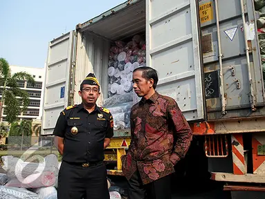 Presiden Joko Widodo berbincang dengan Dirjen Bea Cukai Heru Pambudi saat penindakan barang tekstil impor ilegal di Jakarta, Jumat (16/10/2015). Jokowi menyebut, maraknya impor tekstil ilegal merusak industri nasional. (Liputan6.com/Faizal Fanani)
