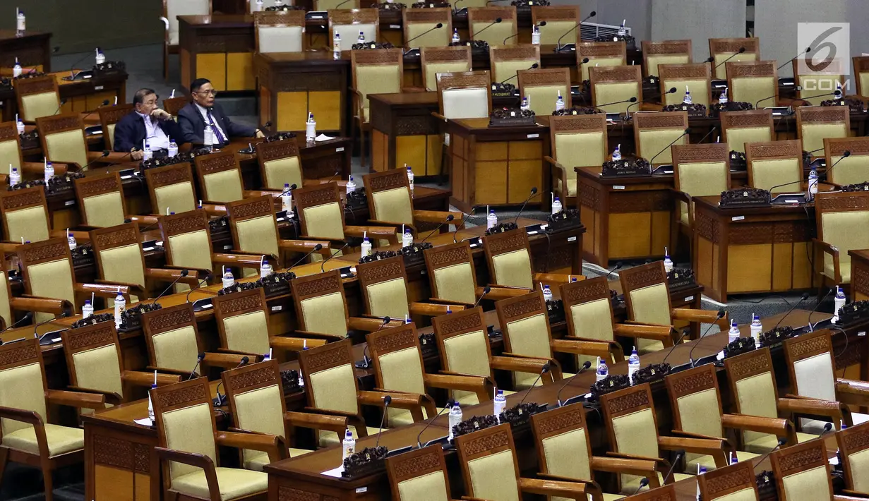 Dua anggota DPR menghadiri rapat paripurna Masa Sidang I Periode 2019-2020 di antara bangku yang tak terisi di Kompleks Parlemen, Senayan, Jakarta, Kamis (22/8/2019). Rapat yang membahas RUU APBN Tahun 2020 beserta nota keuangannya itu hanya dihadiri 55 orang. (Liputan6.com/Johan Tallo)