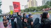 Seorang penonton membawa poster bertema kebakaran hutan dan lahan (karhutla) saat Jakarta Running Festival (JRF) 2026 di sepanjang lintasan Jalan Jenderal Sudirman, Jakarta, Sabtu (24/10/2026). (KLY/Budy Santoso)