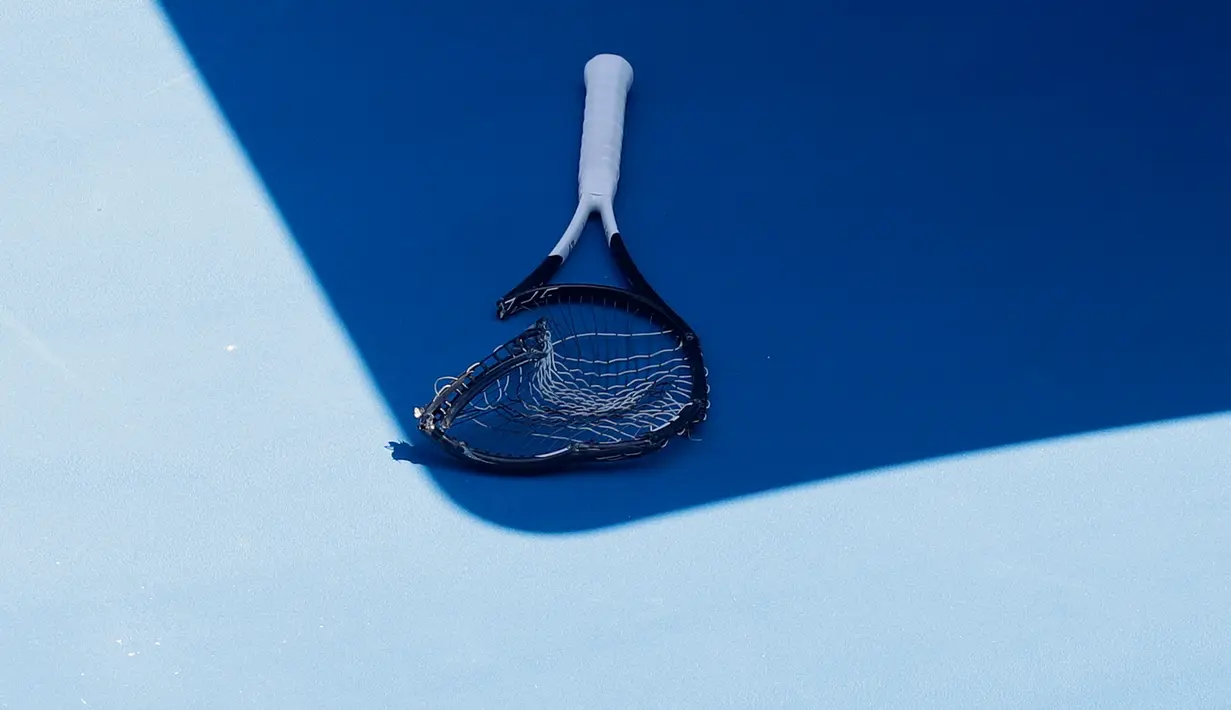 Raket petenis Jerman, Alexander Zverev yang rusak karena dibanting tergeletak di lapangan pada putaran keempat Australia Terbuka  menghadapi Milos Raonic dari Kanada di Melbourne, Senin (21/1). Zverev frustasi kalah dua set 6-1 4-1. (AP/Kin Cheung)