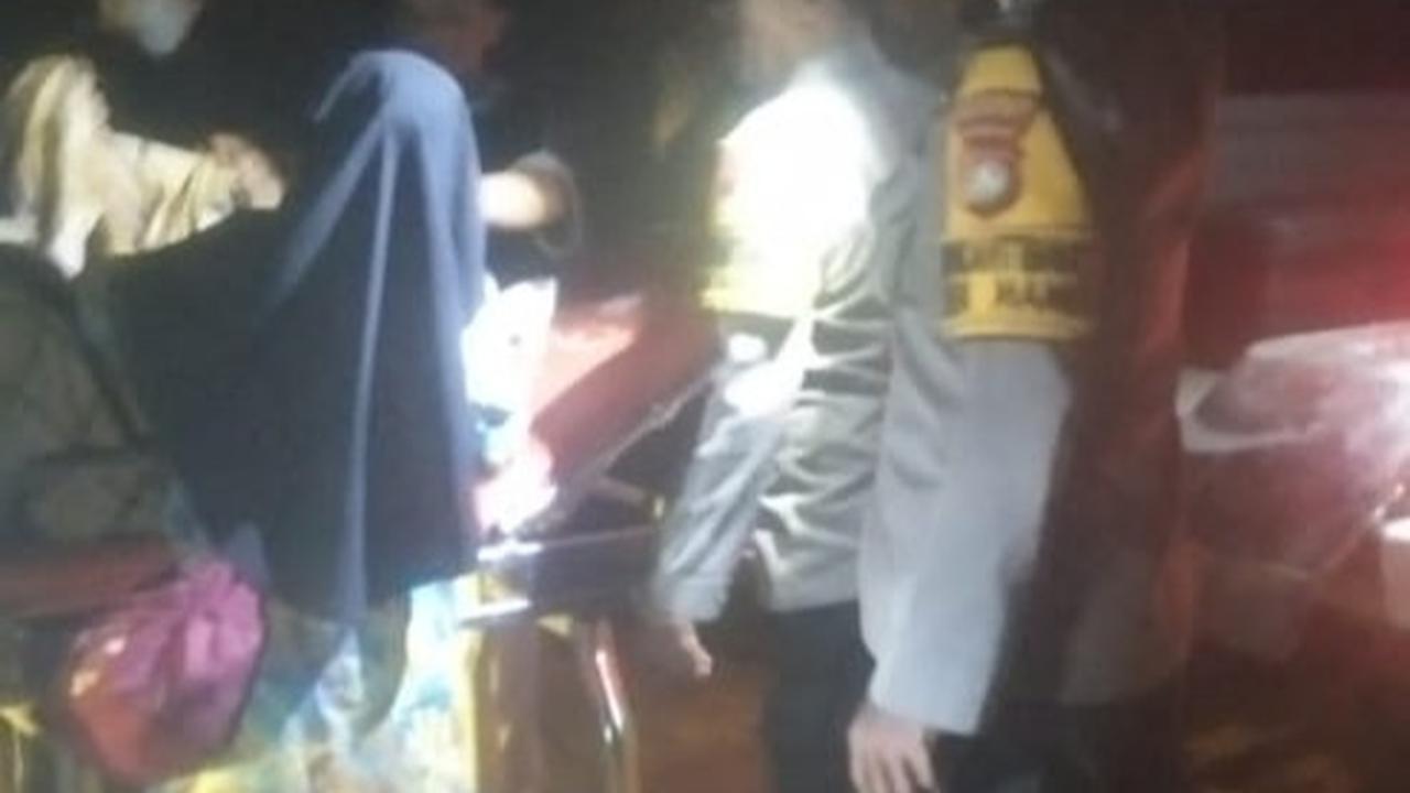 Bhabinkamtibmas Polsek Mambi menggotong lansia sakit menggunakan sarung dan bambu. (merdeka.com/Istimewa).
