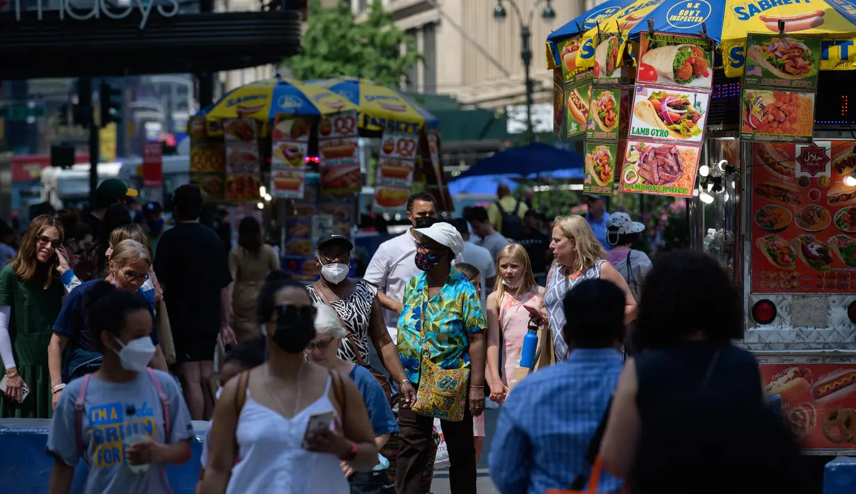 Orang-orang berjalan melalui Herald Square pada hari yang hangat di New York City (7/6/2021). Cuaca yang hangat di New York dimanfaatkan warga untuk membaca buku hingga berjalan-jalan. (AFP/Angela Weiss)