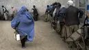 <p>Seorang perempuan Afghanistan menerima jatah makanan yang didistribusikan oleh kelompok bantuan kemanusiaan Korea Selatan, di Kabul, Selasa (10/5/2022). Taliban pada Sabtu pekan lalu memerintahkan semua perempuan Afghanistan menutupi seluruh tubuhnya atau mengenakan burqa tradisional di depan umum. (AP Photo/Ebrahim Noroozi)</p>