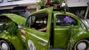 Roberta Machado dari Brasil duduk di Volkswagen Beetle 1969 miliknya yang diubah menjadi toko bunga keliling di Copacabana, Rio de Janeiro, Rabu (14/10/2020). Perempuan 51 tahun ini mengubah VW kodok untuk bertahan dari krisis akibat pandemi COVID-19. (MAURO PIMENTEL/AFP)