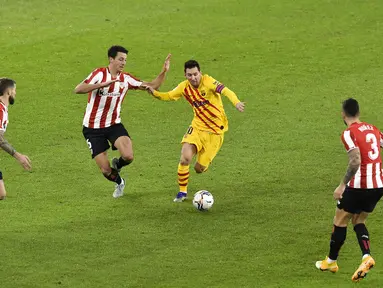 Pemain Barcelona Lionel Messi (kedua kanan) menggiring bola melewati tiga pemain Athletic Bilbao pada pertandingan Liga Spanyol di Stadion San Mames, Bilbao, Spanyol, Rabu (6/1/2021). Barcelona menang 3-2 dengan dua gol dari Lionel Messi. (AP Photo/Alvaro Barrientos)