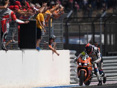 Pebalap asal Prancis, Thomas Chermeux mendorong motornya hingga garis finish pada ajang 80th edition of the Bol d'Or 24-hour motorbike race, di Paul Ricard racetrack, Le Castellet, (18/9/2016).  AFP/Boris Hovrat)