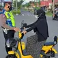 Petugas kepolisian tengah memberikan informasi kepada pengguna sepeda listrik