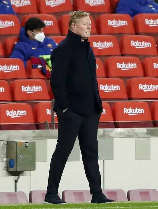 Pelatih Barcelona, Ronald Koeman menyaksikan pemainnya bertanding melawan Sevilla pada pertandingan leg kedua babak semifinal Copa del Rey di stadion Camp Nou di Barcelona, Spanyol, Kamis (4/3/2021). Barcelona menang telak atas Sevilla 3-0. (AP Photo/Joan Monfort)