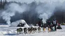 Ryne Olson memandu tim anjingnya melewati api unggun di Sungai Susitna saat dimulainya Iditarod Trail Sled Dog Race di Alaska Selatan, Minggu (7/3/2021). Sled Dog Trail merupakan lomba balap kereta luncur yang ditarik oleh anjing yang digelar tiap tahun. (Bill Roth/Anchorage Daily News via AP)