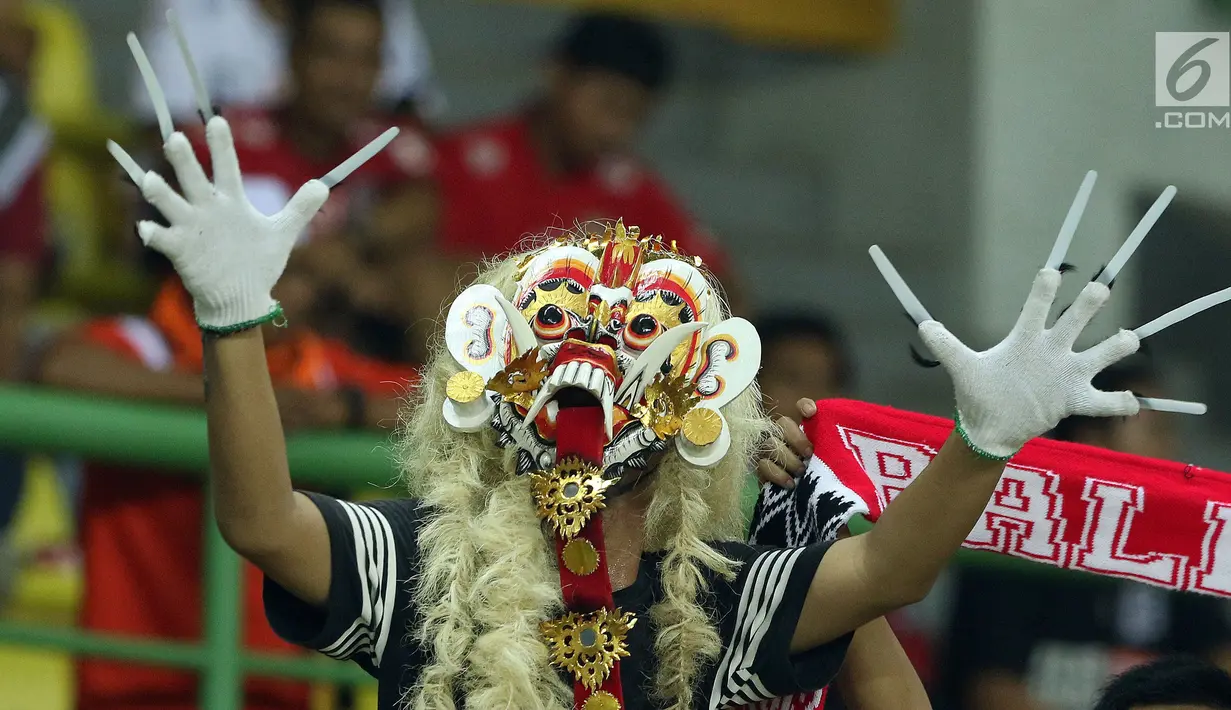 Seorang suporter Serdadu Tridatu mengenakan topeng khas jelang menyaksikan laga Persija melawan Bali United di Stadion Patriot Candrabhaga, Bekasi, Minggu (21/5). Laga kedua tim berakhir imbang 0-0. (Liputan6.com/Helmi Fithriansyah)