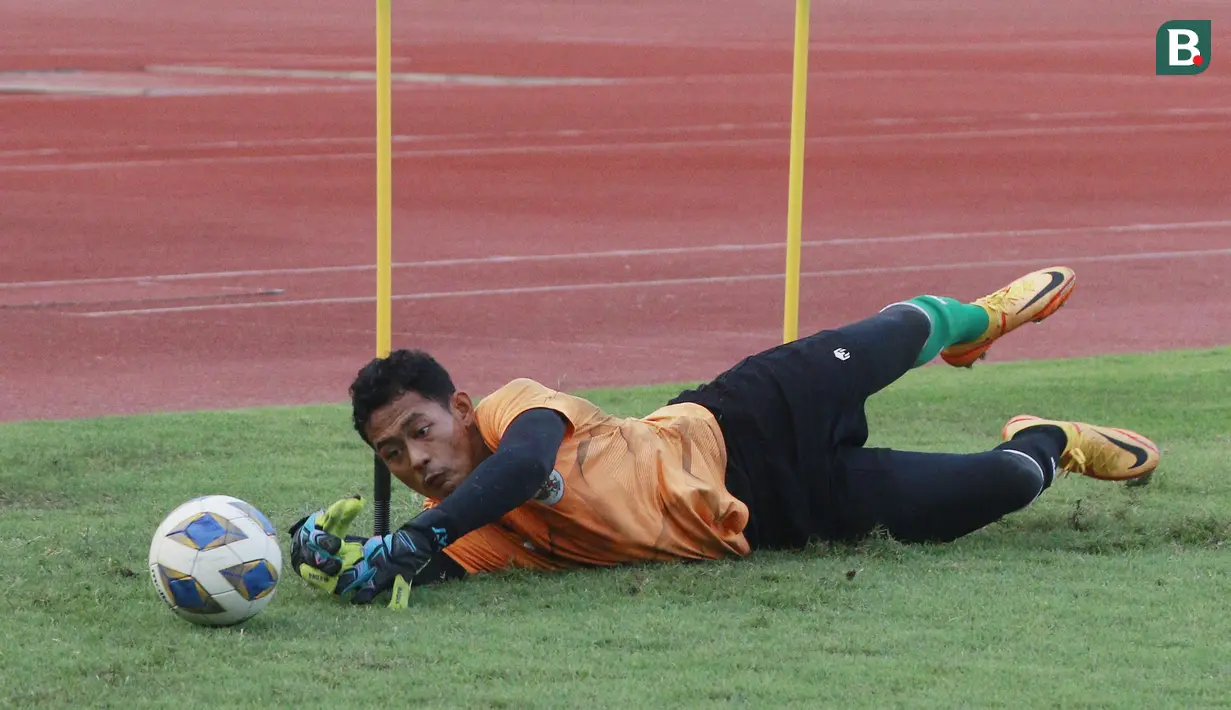 Kiper Timnas Indonesia U-19, Erlangga Setyo, berusaha menangkap bola saat melakukan latihan jelang Piala AFF U-19 2022 di Stadion Madya, Jakarta, Selasa (21/6/2022). (Bola.com/M Iqbal Ichsan)