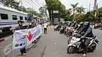 Komunitas Indonesian Railway Preservation Society menggelar spanduk imbauan di perlintasan kereta api, Menteng, Jakarta, Kamis (15/10). Kampanye itu guna menyadarkan masyarakat akan bahaya menerobos perlintasan kereta api. (Liputan6.com/Immanuel Antonius)
