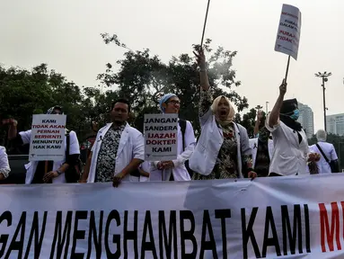 Massa dari Pergerakan Dokter Muda Indonesia melakukan aksi di depan Istana Negara, Jakarta, Kamis (19/7). Mereka ingin mengadukan isu terkait pungli yang dilakukan Fakultas Kedokteran dan Kemenristek Dikti Ke Presiden Jokowi. (Liputan6.com/Johan Tallo)