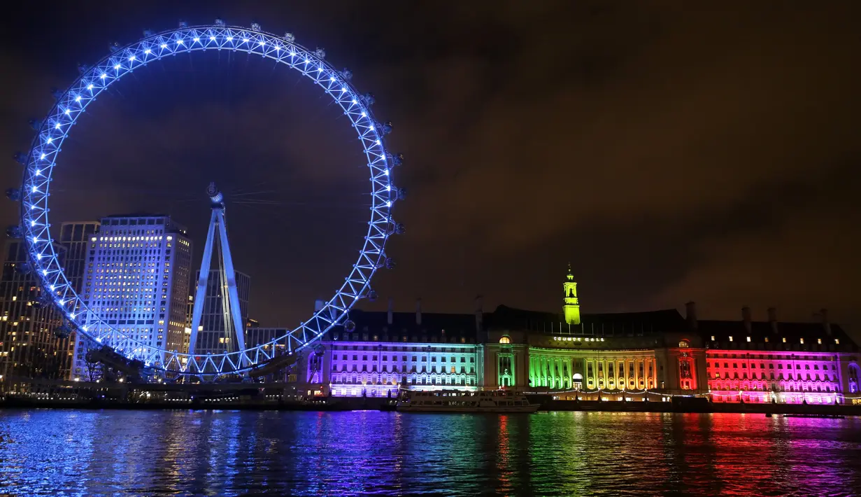 Cahaya biru menerangi London Eye di tepi Sungai Thames untuk berterima kasih kepada National Health Service (NHS) di London, Kamis (7/1/2021). NHS merupakan sistem layanan kesehatan nasional yang menjadi ujung tombak Inggris dalam memerangi pandemi Covid-19. (AP Photo/Kirsty Wigglesworth)