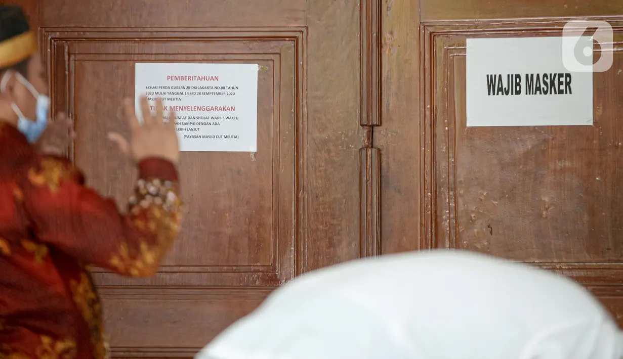 Pesan pemberitahuan wajib menggunakan masker terpampang di Masjid Cut Meutia, Jakarta, Jumat (18/9/2020). Pemprov DKI Jakarta kembali meniadakan kegiatan ibadah salat Jumat dan salat lima waktu berjemaah di semua Masjid Raya selama PSBB. (Liputan6.com/Faizal Fanani)
