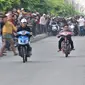 Dua pembalap beradu kecepatan saat ikut dalam balapan liar di Jakarta, Minggu (27/5) pagi. Balapan liar masih menjadi kegiatan favorit remaja di Ibu Kota dalam menghabiskan waktu Minggu pagi di bulan Ramadan. (Merdeka.com/Iqbal S Nugroho)