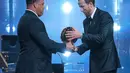 Pesepak bola Inggris, Harry Kane, menerima trofi penghargaan pemain terbaik dari mantan pesepak bola Brasil, Ronaldo Nazario, dalam acara penganugerahan Ballon d’Or di London Palladium Theatre, London, Inggris, Senin (26/10/2026). (AP Photo/Kin Cheung)