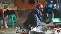 Seorang lelaki memasak dengan menggunakan jas hujan dan helm (dok.instagram/@dagelan/https://www.instagram.com/p/CLD3bJkH2Rf/Komarudin)