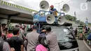 Petugas kepolisian yang berjaga memberhentikan mobil komando aksi di sekitar Gedung DPR, Jakarta, Jumat (14/8/2020). Polda Metro Jaya melarang adanya unjuk rasa di depan Gedung DPR/MPR yang bertepatan dengan sidang tahunan sekaligus pidato kenegaraan Presiden Jokowi. (Liputan6.com/Faizal Fanani)