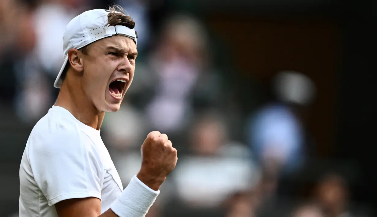 Petenis Denmark Holger Rune merayakan kemenangan satu poin melawan Grigor Dimitrov dari Bulgaria selama pertandingan tenis tunggal putra putaran keempat turnamen Wimbledon di The All England Tennis Club di Wimbledon, London barat daya, pada 10 Juli 2023. (SEBASTIEN BOZON / AFP)