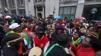 Warga Zimbabwe yang menetap di Inggris menggelar aksi protes di luar Kedutaan Besar Zimbabwe di London, Sabtu (18/11). Tak hanya menggelar long march, mereka juga menari dan minum bersama sambil menyerukan teriakan agar Mugabe mundur. (NIKLAS HALLE'N/AFP)