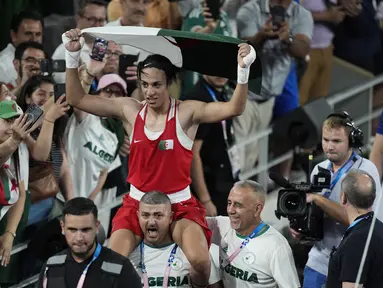 Petinju asal Aljazair, Imane Khelif, diarak staf pelatih setelah berhasil meraih medali emas Olimpiade Paris 2024 dari cabang olahraga tinju nomor putri. (AP Photo/John Locher)