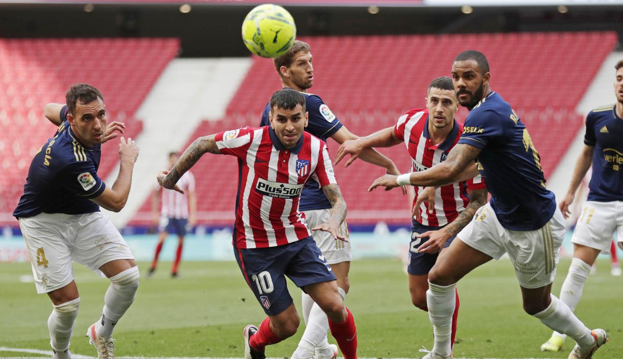 Pemain Atletico Madrid, Angel Correa, berusaha melewati pemain Osasuna pada laga Liga Spanyol di Stadion Wanda Metropolitano, Minggu (16/5/2021). Atletico Madrid menang dengan skor 2-1. (AP/Manu Fernandez)