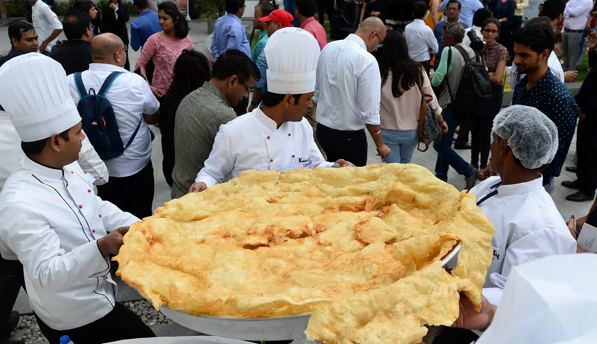 Roti goreng Bhatura dengan diameter 147 cm telah selesai dibuat, India, New Delhi, Kamis (6/4). Penyelenggara berharap Bhatura buatan mereka bisa memecahkan rekor Bhatura  terbesar di India. (AFP PHOTO / SAJJAD HUSSAIN)