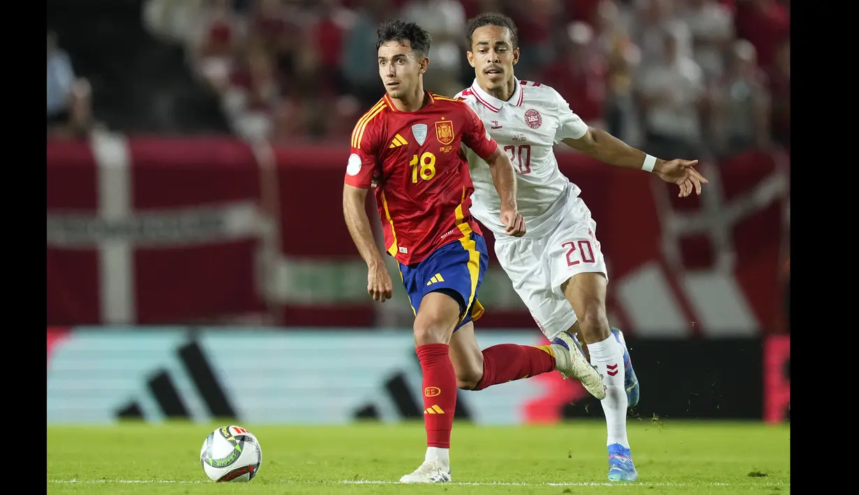 Pemain Spanyol, Martin Zubimendi (kiri) berebut bola dengan pemain Denmark, Yussuf Poulsen pada laga lanjutan UEFA Nations League di Nueva Condomina Stadium, Murcia, Spanyol, Minggu (13/10/2024) dini hari WIB. (AP Photo/Jose Breton)