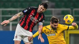 Bek AC Milan, Alessio Romagnoli (kiri) berduel udara dengan striker Udinese, Fernando Llorente dalam laga lanjutan Liga Italia 2020/21 pekan ke-25 di San Siro Stadium, Rabu (3/3/2021). AC Milan bermain imbang 1-1 dengan Udinese. (AFP/Miguel Medina)