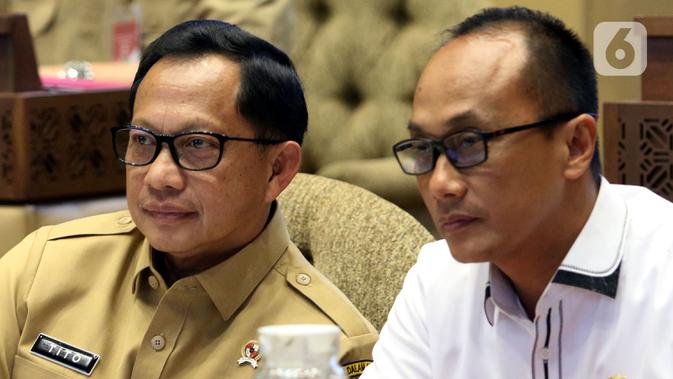 Menteri Dalam Negeri (Mendagri) Tito Karnavian (kiri) saat mengikuti rapat kerja dengan Komisi II DPR di Kompleks Parlemen, Jakarta, Selasa (26/11/2019). Rapat membahas pergeseran anggaran Kemendagri 2019 dan kebutuhan anggaran blangko e-KTP. (Liputan6.com/Johan Tallo)