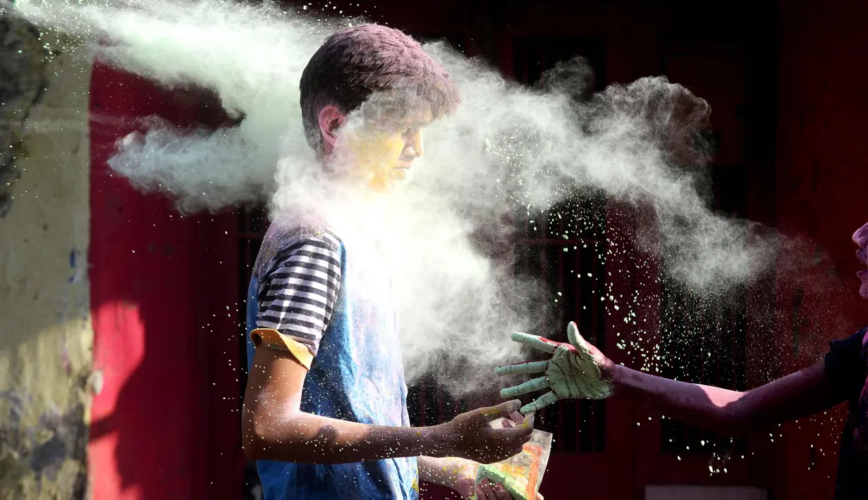 Seorang anak India terkena tepun selama perayaan festival Holi di Chennai (2/3). Holi, festival musim semi hindu di India yang diadakan 2 Maret tahun ini pada akhir musim dingin pada bulan purnama pertama kalender lunar. (AFP Photo/Arun Sankar)
