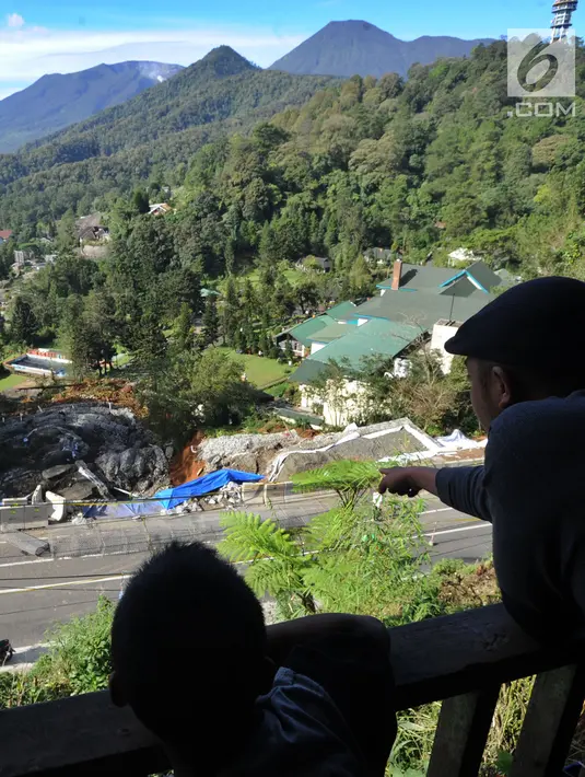 Warga melihat area longsor dari ketinggian di kawasan Ciloto, Cianjur, Jawa Barat, Kamis (29/3). Tebing di bahu Jalan Raya Puncak itu kembali mengalami longsor dengan kedalaman 40 meter dan panjang lebih kurang 150 meter. (Merdeka.com/Arie Basuki)