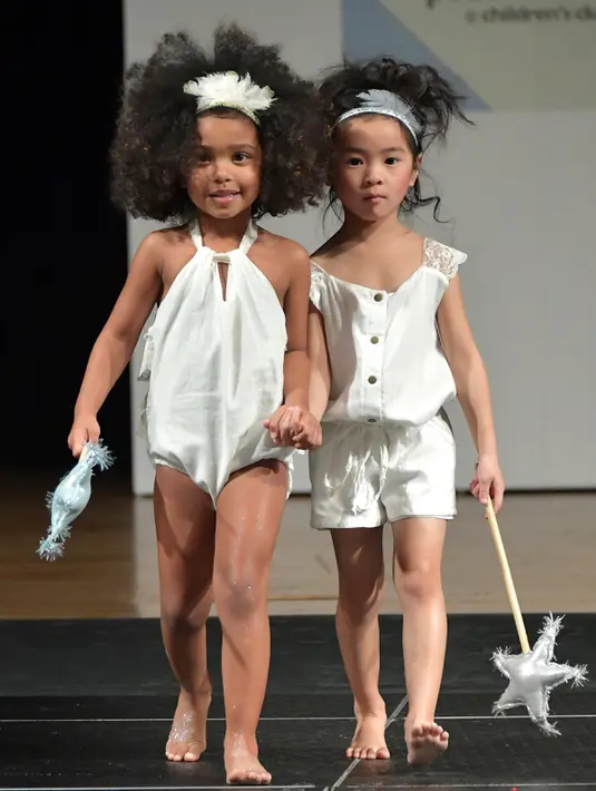 Dua model cilik berjalan di atas catwalk membawakan busana Wild and Fierce selama petitePARADE di Children's Club di Jacob Javits Center, New York, AS (9/1). (Mike Coppola/Getty Images for petitePARADE/AFP)