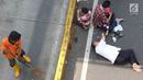 Warga beristirahat saat pasukan oranye membersihkan sampah selama Car free day (CFD) di Jalan Warung Jati Barat, Jakarta, Minggu (17/9). CFD kembali digelar untuk kedua kalinya di kawasan Mampang Prapatan hingga Pejaten. (Liputan6.com/Immanuel Antonius)