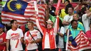 Suporter Indonesia dan Malaysia berdampingan memberi dukungan untuk jagoannya masing-masing saat final bulutangkis Olimpiade Rio 2016  di Stadion Riocentro, Rio de Janeiro, (17/8/2016). (AFP/Goh Chai Hin)