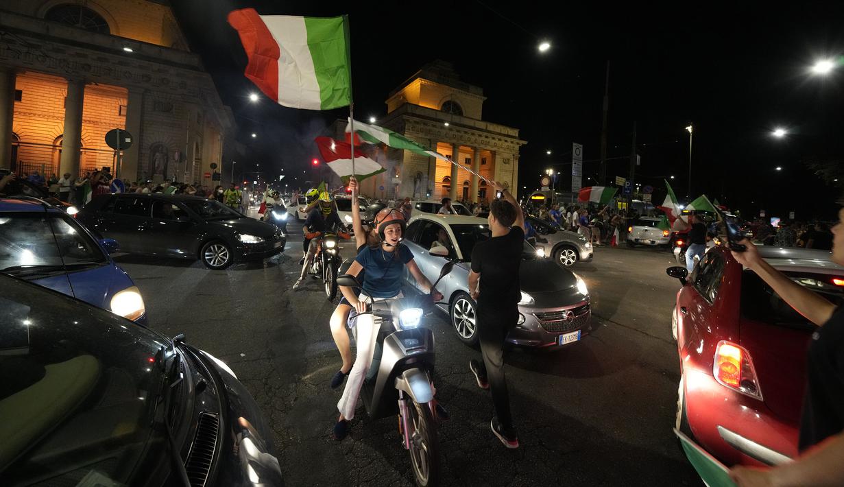 Pendukung Italia merayakan kemenangan di Milan, Italia pada Senin (12/07/2021), setelah Italia berhasil mengalahkan Inggris pada Final Euro 2020 yang berlangsung di Stadion Wembley, London, Inggris. Italia mengalahkan Inggris 3-2 dalam adu penalti setelah bermain imbang 1-1. (AP/Luca Bruno)