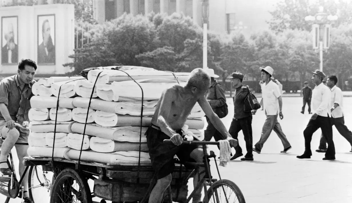 Seorang pria mengendarai gerobak yang penuh dengan barang dagangan di kota Beijing, China pada 23 Juli 1973.  (AFP Photo)