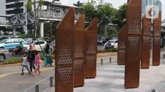 Warga melintasi sebuah instalasi di kawasan Sudirman, Jakarta, Sabtu (23/11/2019). Pemprov DKI Jakarta gencar membangun dan menyediakan ruang publik bagi masyarakat, baik untuk pegawai kantoran hingga mahasiswa, yang berlalu lalang agar bebas menikmati ruang ini. (Liputan6.com/Angga Yuniar)