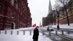 Pendukung komunis tua membawa bendera merah bekas Uni Soviet akan meletakkan bunga di makam pemimpin Soviet Josef Stalin pada peringatan 142 tahun kelahirannya di dekat Tembok Kremlin di Lapangan Merah dengan makam Lenin di kanan di Moskow, Rusia (21/12/2021). (AP Photo/Alexander Zemlanichenko)