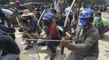 Pengunjuk rasa anti-kudeta menyiapkan busur dan anak panah darurat untuk menghadapi polisi di kota Thaketa Yangon, Myanmar  (27/3/2021).  Kepala junta Myanmar menggunakan kesempatan Hari Angkatan Bersenjata untuk mencoba membenarkan penggulingan pemerintahan terpilih Aung San Suu Kyi. (AP Photo)