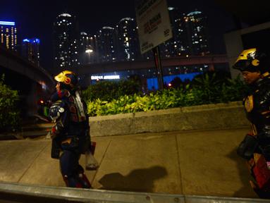 Dua robot berjalan saat menghibur pengendara di kawasan Tomang, Jakarta, Selasa (14/9/2021). Abi (20) dan Nujum (48) mengenakan kostum robot Iron Man untuk mengais rejeki dan menghibur para pengendara dari kemacetan lalu lintas yang dilakukan sejak pandemi COVID-19. (merdeka.com/Imam Buhori)